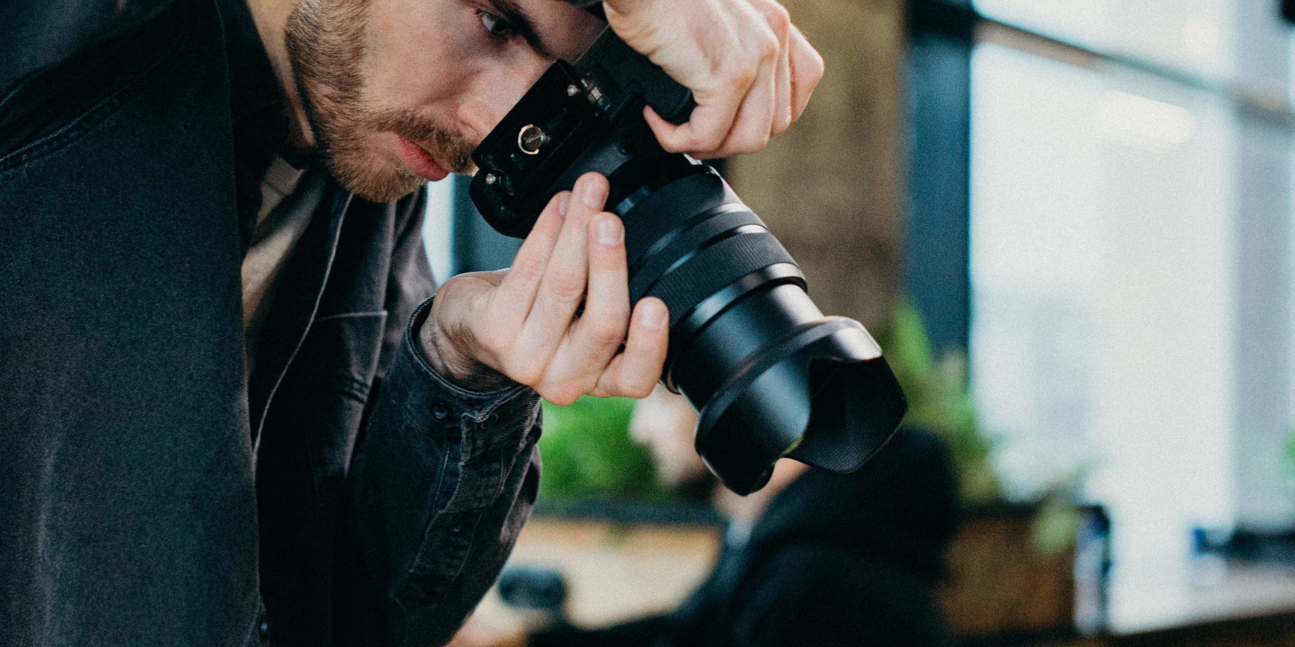 man-holding-black-dslr-camera-3584932
